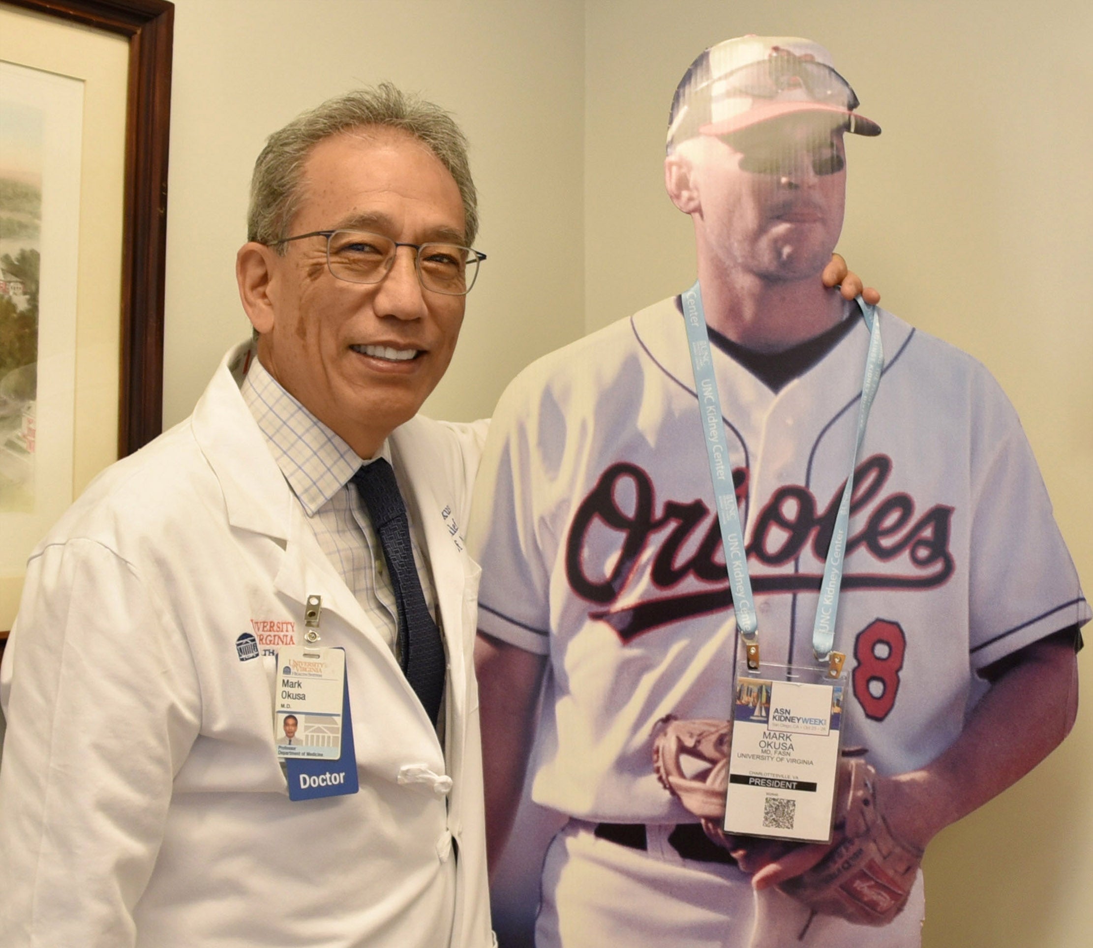 Lab member posing with a baseball player cut out